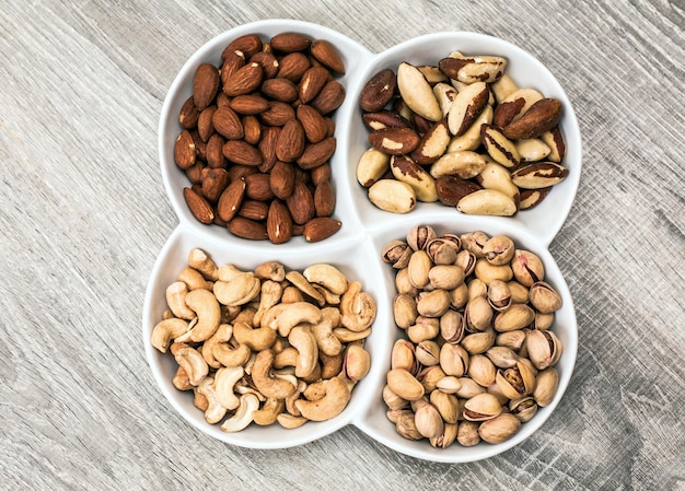 Vue de dessus d'une assiette avec des cacahuètes, des pistaches et une noix anglaise