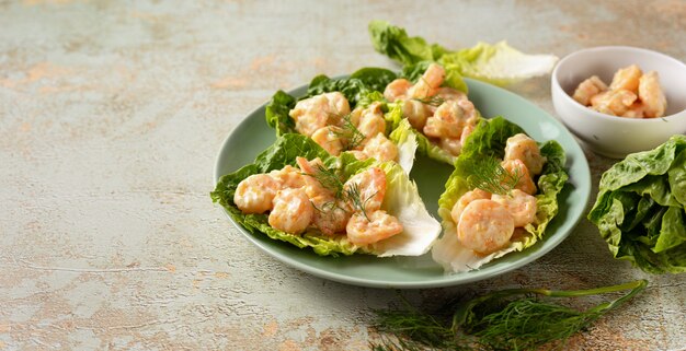 Vue de dessus d'une assiette avec des crevettes sur les feuilles de salade verte