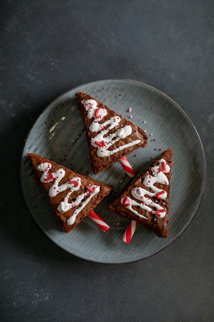 Vue de dessus de l'assiette avec dessert d'arbre de Noël à base de brownie au chocolat sur fond sombre. Concept de cuisine de vacances