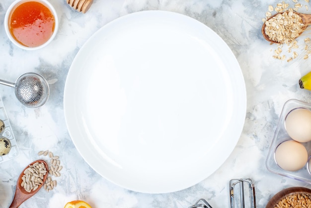 Vue de dessus de l'assiette vide blanche et des ingrédients pour les aliments sains sur la table de glace