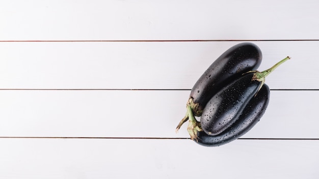 Photo vue de dessus des aubergines fraîches sur une planche en bois