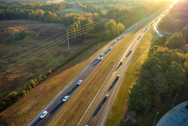 Vue de dessus de l'autoroute américaine très fréquentée avec un trafic rapide entre les bois d'automne concept de transport inter-États