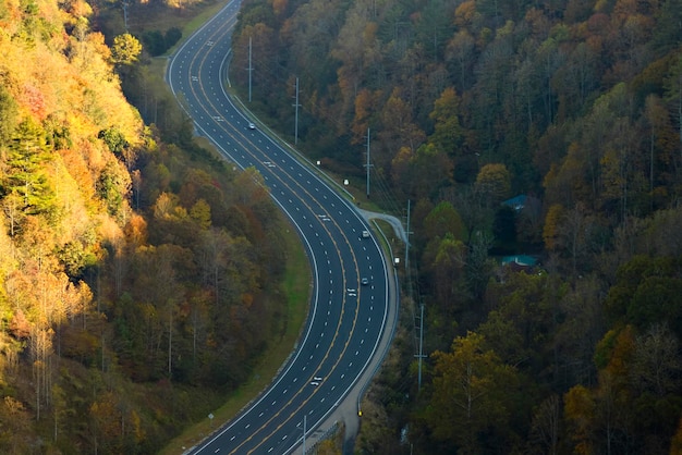 Vue de dessus de l'autoroute nationale en Caroline du Nord menant à travers les Appalaches avec des bois d'automne jaunes et des camions et des voitures en mouvement rapide Concept de transport inter-États