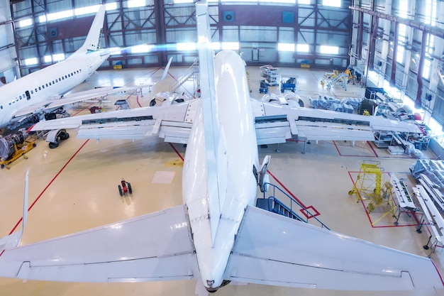 Vue de dessus d'un avion de passagers blanc dans le hangar Avions en maintenance
