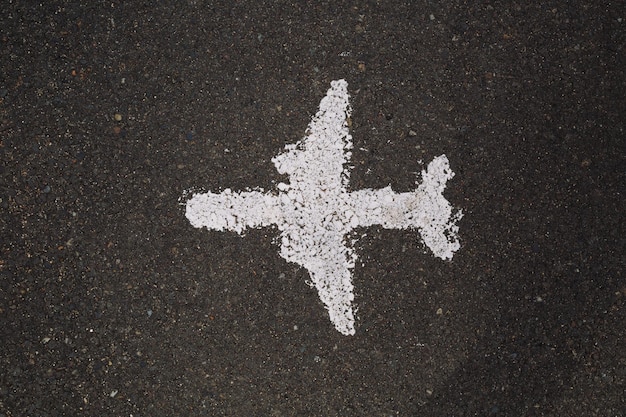 Vue de dessus d'un avion peint en blanc sur une route goudronnée