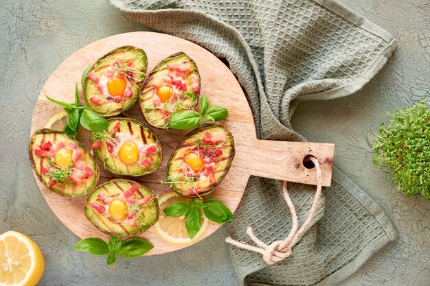 Vue de dessus sur les bateaux d'avocat grillés avec bacon et œufs de caille