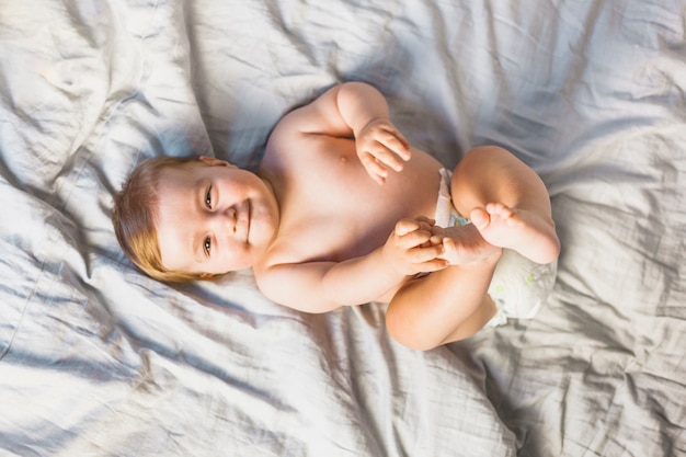 Photo vue de dessus bébé blonde sur un lit