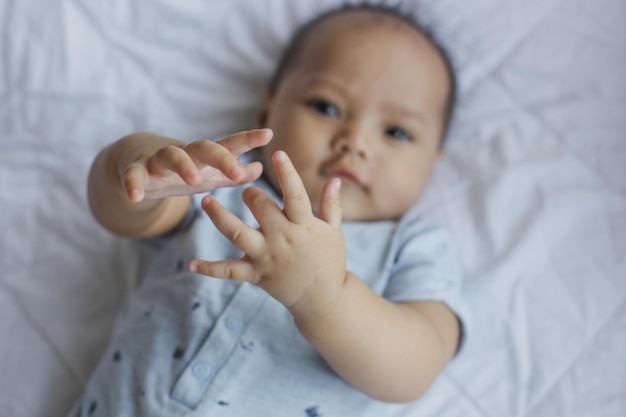 Vue de dessus d'un bébé mignon souriant à la caméra sur le lit