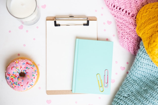 Vue de dessus beignet et presse-papiers sur le bureau