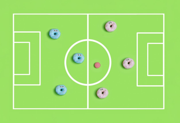 Vue de dessus des beignets colorés drôles jouant au football, concept de temps de fête pour enfants