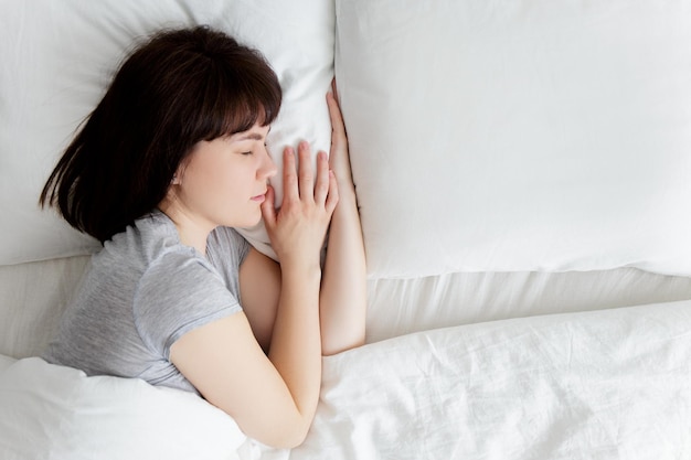 Vue de dessus d'une belle femme dormant dans son lit seule à la maison