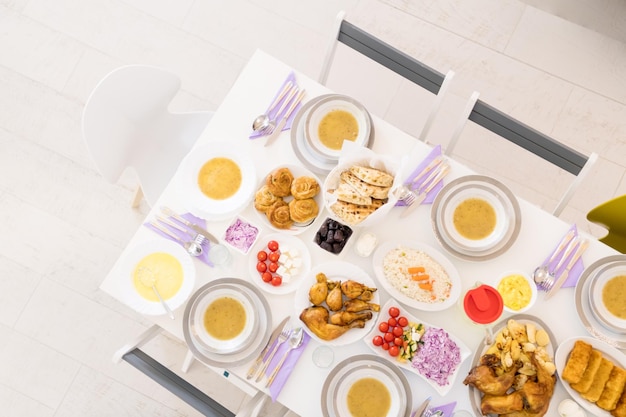 vue de dessus de la belle nourriture colorée décorée et servie pour le dîner de l'iftar sur la table blanche pendant la fête du ramadan à la maison