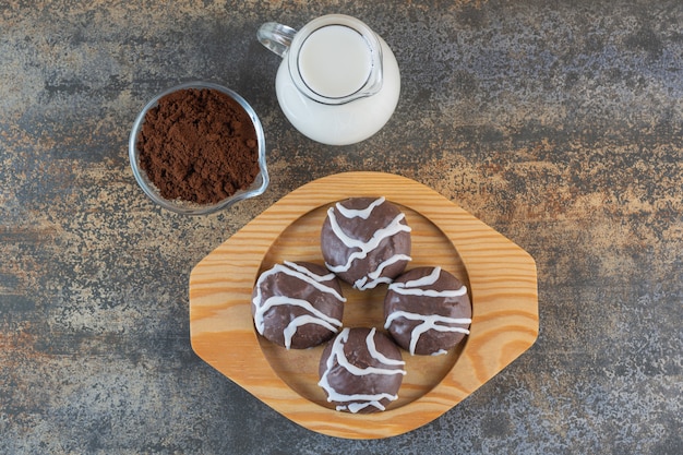 Vue de dessus des biscuits au chocolat sur une plaque en bois avec du lait