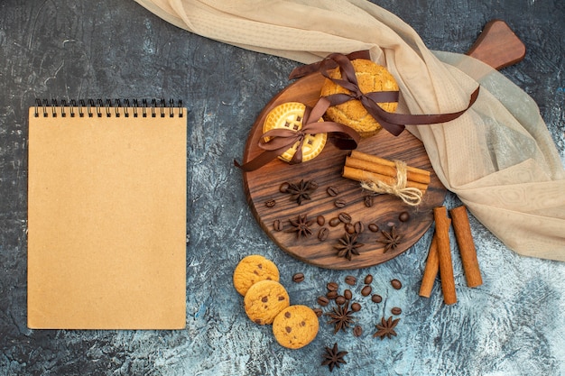 Vue de dessus des biscuits empilés limes à la cannelle sur une planche à découper en bois et un cahier de serviette nue sur fond de glace