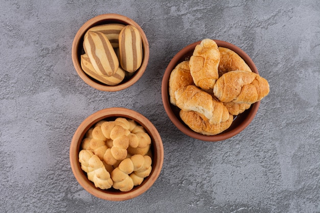 Vue de dessus des biscuits frais faits maison dans des bols sur fond gris.