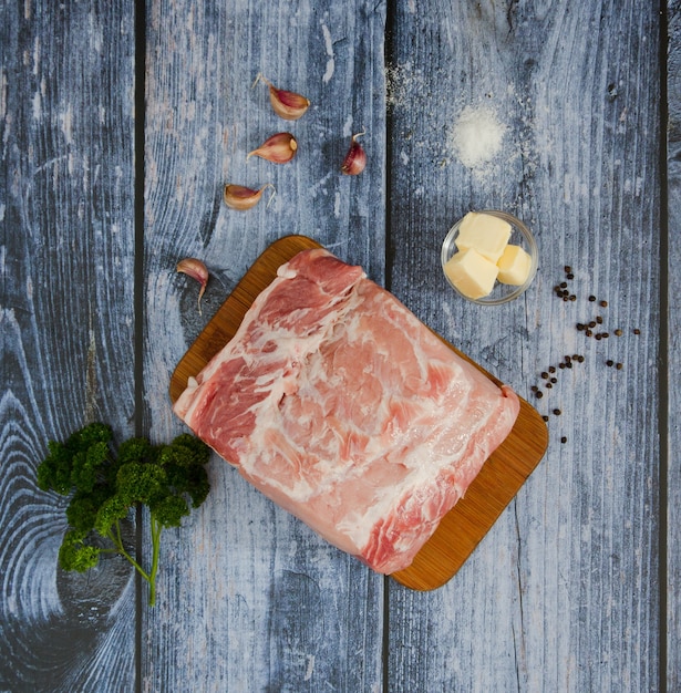 Vue de dessus d'un bloc de viande de porc crue sur une planche