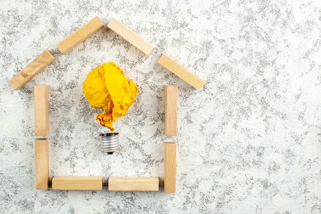 vue de dessus blocs de bois maison forme idée ampoule concept sur fond gris blanc avec espace libre