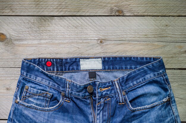 Vue de dessus de blue jeans sur une surface en bois. Concept beauté, mode et shopping