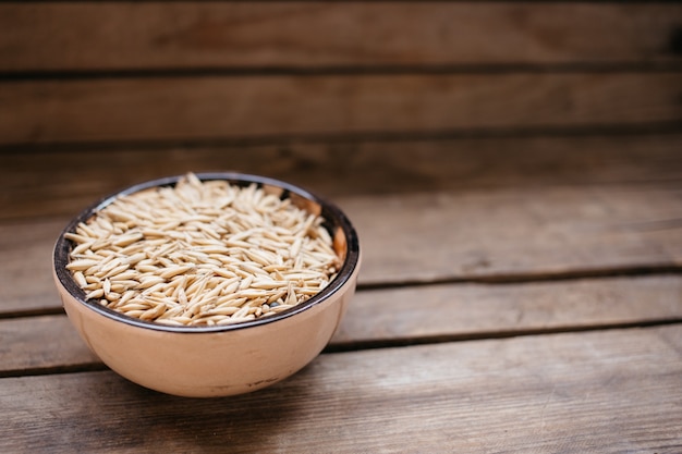 Vue de dessus un bol de grains d&#39;avoine sur un fond en bois, aliments naturels