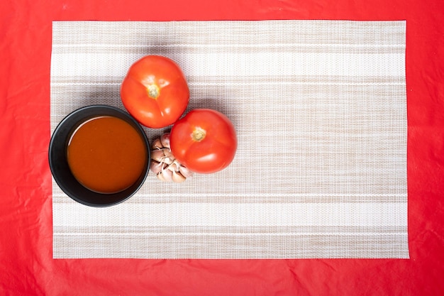 Vue de dessus d'un bol de sauce et des ingrédients tomate et ail