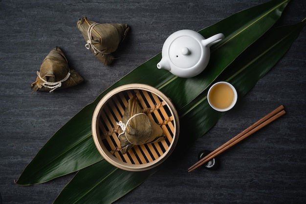 Vue de dessus de boulettes de riz Zongzi pour le festival traditionnel chinois des bateaux-dragons (festival de Duanwu) sur fond d'ardoise noire foncée