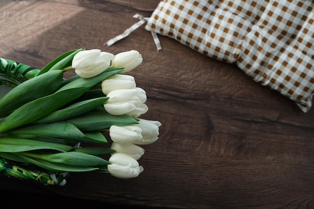 Une vue de dessus d'un bouquet de belles tulipes blanches dans un panier en osier décoratif blanc
