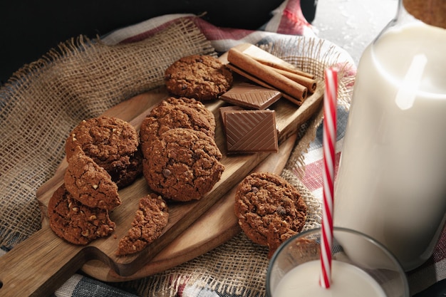 Vue de dessus de la bouteille de lait avec des biscuits sur planche de bois