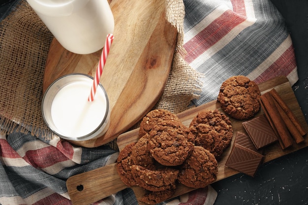 Vue de dessus de la bouteille de lait avec des biscuits sur planche de bois