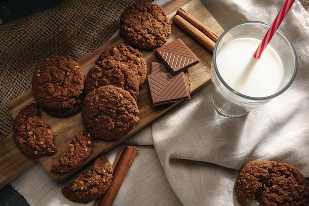 Vue de dessus de la bouteille de lait avec des biscuits sur planche de bois