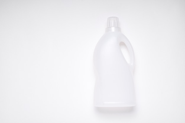 Vue de dessus bouteille de produit de nettoyage en plastique vide blanc sur fond blanc avec espace de copie pour l'image de marque, concept de déchets en plastique