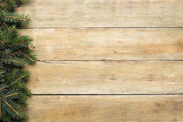 Vue de dessus des branches d'arbres de Noël sur table en bois