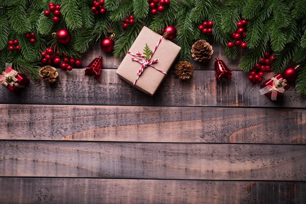 Vue de dessus des branches d&#39;épinette de Noël, des pommes de pin, des baies rouges et une cloche sur le dos en bois ancien