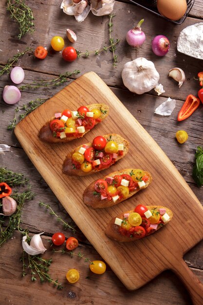 Vue de dessus bruschetta maison italienne sur planche à découper en bois avec assaisonnement