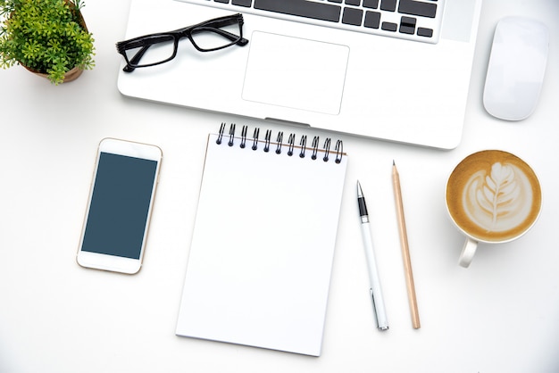 Vue de dessus avec bureau avec ordinateur portable, téléphone portable, tasse à café crayon pour ordinateur portable et lunettes au bureau.