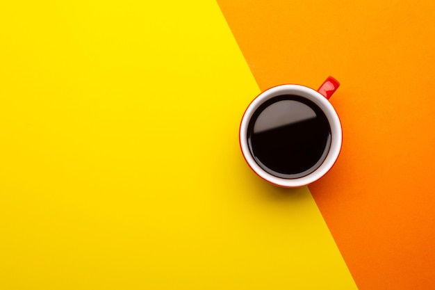 Vue de dessus café noir ou Americano dans une tasse rouge isolé sur jaune