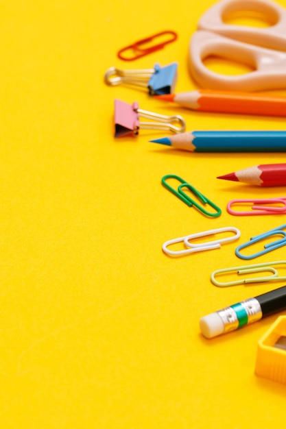 Vue de dessus des cahiers et accessoires étudiant dans la bibliothèque à l'école fond jaune idée éducation