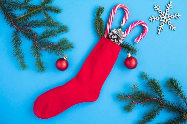 Vue de dessus de la chaussette rouge de Noël avec des cadeaux sur fond bleu. Fermer.