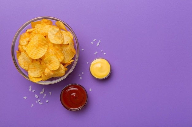 Vue de dessus chips avec sause dans un bol sur fond coloré vue de dessus avec espace de copie