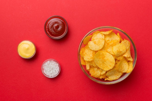 Vue de dessus chips avec sause dans un bol sur fond coloré vue de dessus avec espace de copie