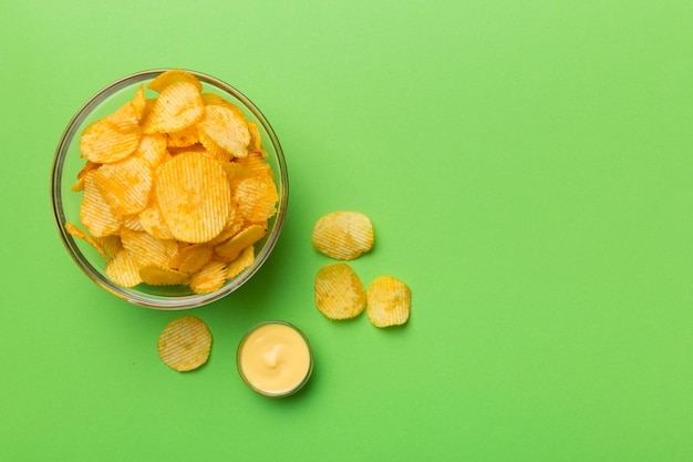 Vue de dessus chips avec sause dans un bol sur fond coloré vue de dessus avec espace de copie