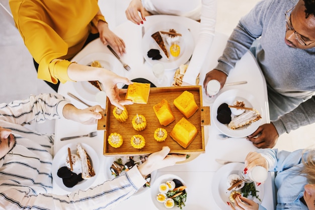 Vue De Dessus De Cinq Amis Multiculturels Assis à Table à Manger Et Déjeuner Sain.