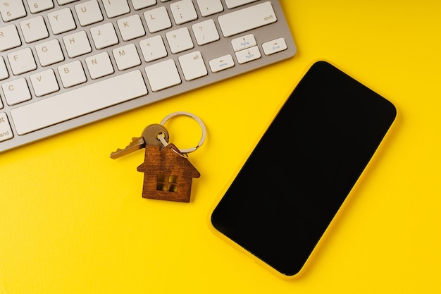 Vue de dessus de la clé de la maison avec concept de maison intelligente pour smartphone et clavier