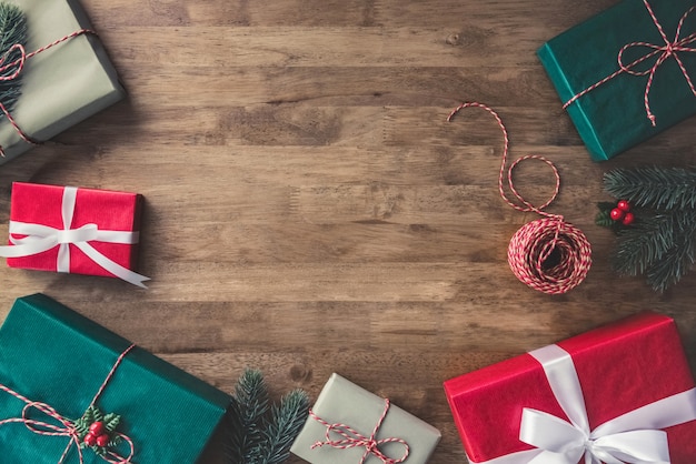 Vue de dessus des coffrets-cadeaux de Noël sur une table en bois avec pins et gui