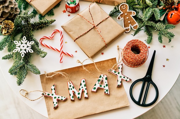 Vue de dessus composition de coffrets cadeaux de Noël faits à la main placés sur une table avec diverses décorations et ciseaux