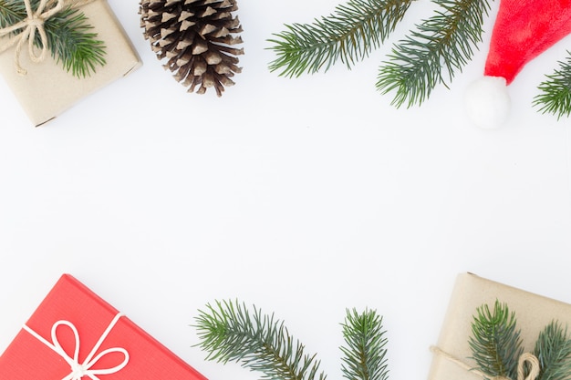 Vue de dessus de la composition de Noël, boîte de cadeau, pommes de pin, branches de sapin sur fond blanc et espace de la copie pour l'information de texte