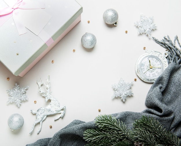 Vue de dessus composition de Noël ou du nouvel an sur un fond gris et blanc avec des décorations de Noël blanches et argentées, cerfs, flocons de neige, boules et horloge