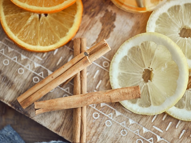 Vue de dessus de la composition de tranches de citrons et d'oranges juteuses avec des épices placées sur une planche de bois