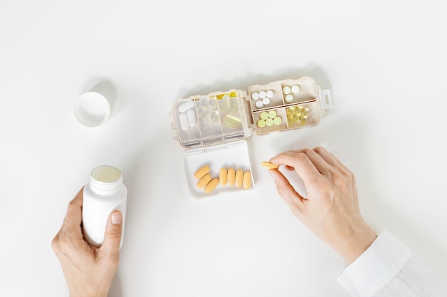 Vue de dessus comprimés médicaux suppléments nutritionnels sur la table boîte à pilules médecine organisateur de pilules hebdomadaire