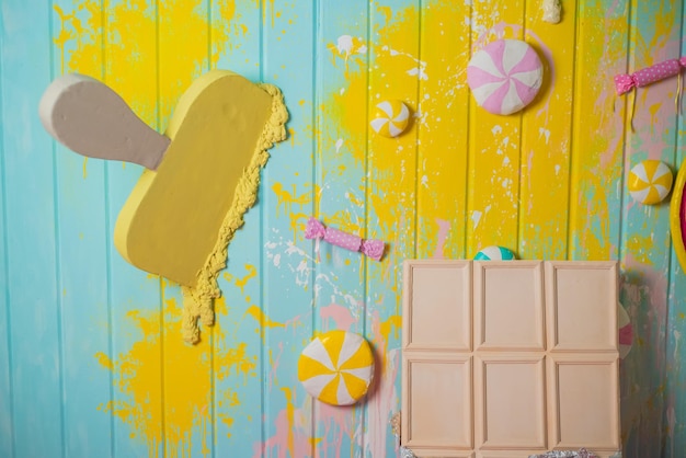 Vue de dessus Conception de modèle Flatlay d'une barre de chocolat blanc et de crème glacée sur un fond en bois jaune menthe avec espace de copie Vue de dessus Modèle de conception Flatlay d'un groupe de bonbons