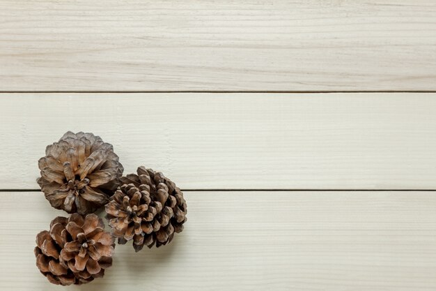 Vue de dessus des cônes de pin sur fond de table en bois.